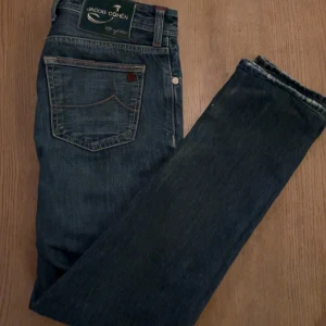Jeans från Jacob Cohën - Snygga jeans från Jacob Cohën i en klassisk blå färg. De har en slim fit  passform och är tillverkade i högkvalitativt denim. Byxorna har knappar och en stilren design med en broderad logga på baksidan. Byxorna är limited edition. Om ni har några funderingar eller prisförslag är de bara att skriva!