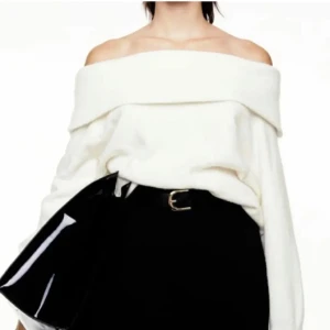 Vit offshoulder tröja - Säljer en stilren vit offshoulder tröja med en bred krage. Perfekt för en trendig look och kan enkelt matchas med olika outfits. Tröjan har en lös passform och är tillverkad i ett mjukt material.