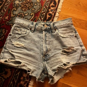 Jeansshorts  - Säljer ett par ljusa jeansshorts från Zara med slitna detaljer och knappgylf. De är väl använda men superbra skick säljer då jag växt ur dom💕