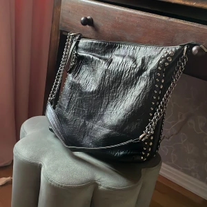 Svart kedje axelväska⭐️ - Svart axelväska i skinn med nitar längs kanterna. Är i gott skick och säljer för den inte kommer till användning längre💗⭐️