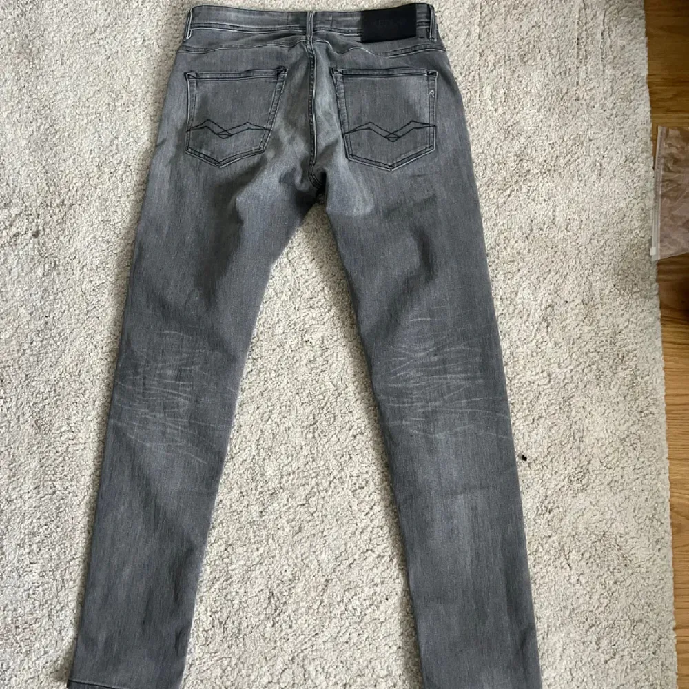 Snygga grå jeans från Replay med en klassisk femficksdesign. De har en stilren look med en diskret logga på bakfickan. Perfekta för en avslappnad stil.. Farkut & Housut.