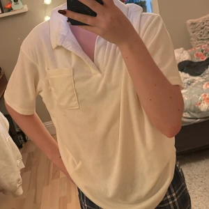 Vit kortärmad t-shirt från 157 - Säljer en vit kortärmad t-shirt från 157 i storlek S. T-shirten har en klassisk krage och en bröstficka. Perfekt för en avslappnad stil.