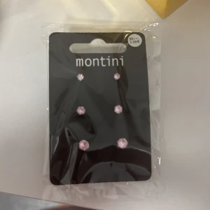 Rosa örhängen från Montini - Säljer ett set med tre par rosa örhängen från Montini. De är små och eleganta, perfekta för att lägga till en subtil touch av färg till din outfit. Kommer i originalförpackning.