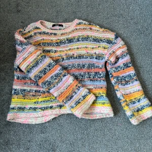 Flerfärgad stickad tröja från Bikbok - Säljer en mysig flerfärgad stickad tröja från Bikbok. Tröjan har ett randigt mönster i olika färger som rosa, blå, gul och orange. Den är långärmad och perfekt för kyligare dagar. Passar bra till jeans eller kjol. Passar både Xs/S. 