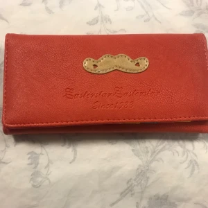 Dam Färger plånbok  - Snygg dam plånbok från Easternstar med ett unikt mönster och flera fack för kort och mynt. Insidan har färgglada detaljer i blått, gult och rosa samt ett fack med dragkedja. Perfekt för att hålla ordning på dina tillhörigheter.  Mått ca 18.00*8.50*2.00 cm . 135kr/st . Helt ny 