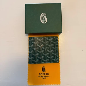 Grön plånbok   - Säljer en elegant grön plånbok. Plånboken har flera kortfack och en sedelficka, perfekt för att hålla ordning på dina kort och kontanter. Kommer med originalförpackning och tygpåse.