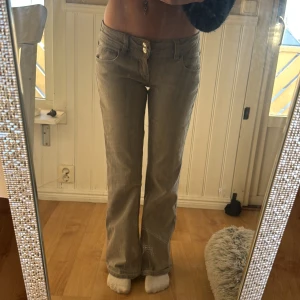 Grå bootcut jeans från Gina Tricot - Snygga grå bootcut jeans från Gina Tricot med dubbla knappar i midjan.