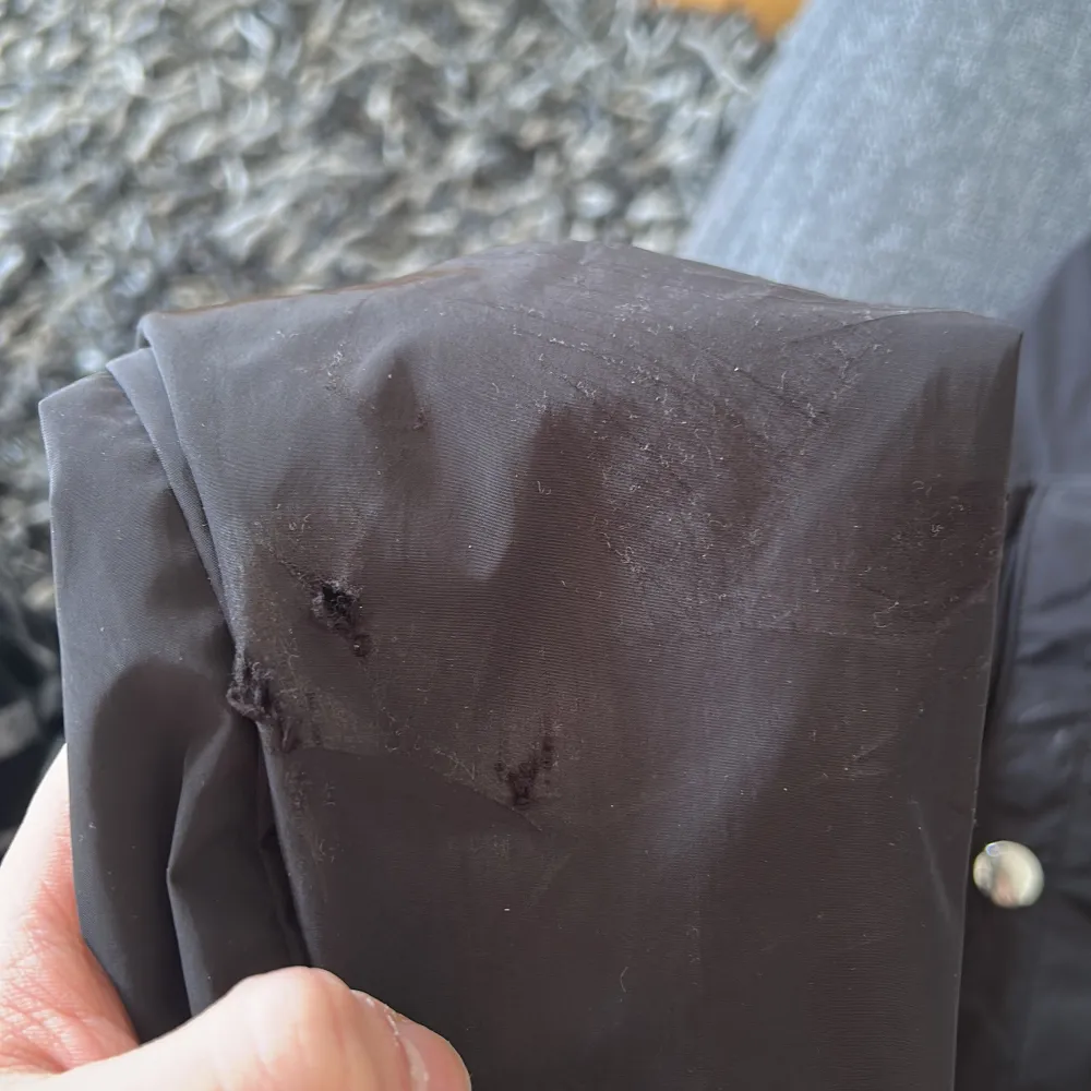 Snygg svart vindjacka från Moncler med dragkedja. Jackan har Moncler-logga på ärmen och detaljer i rött, vitt och blått på huvan. Perfekt för blåsiga dagar. Lite trasig vid moncler märket och på vänster armen( då jag ramlade en gång med jackan). Annars i bra skick. Storlek 2/M men passar 1/S. Takit.