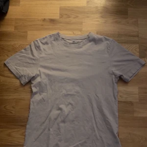 Damm rosa t-shirt från H&M - Säljer en enkel och stilren damm rosa t-shirt från H&M. Perfekt för en avslappnad look. T-shirten har korta ärmar och en rund halsringning. Strlk 146/152