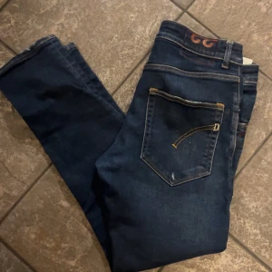 Dondup jeans - Snygga mörkblå dondup jeans med klassisk femficksdesign och kontrastsömmar. Perfekta för en avslappnad stil. De har en dragkedja och knapp framtill. Helt toppenskick och riktigt snygg tvätt!