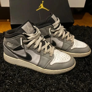 Nike Air Jordans i grått och svart - Snygga Nike Air Jordans i grått och svart med klassisk design. Köpte dom för någon sommar sen på Merch Sweden och har knappt använt dom så vill därför nu bli av med dom. Priset är satt därför jag vill bli av med de fort!