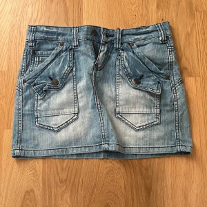 Blå jeanskjol från Object - Snygg blå jeanskjol från Object med coola fickdetaljer och knappar fram. Den är  ultra low waist i midjan och har inga defekter då den är använd ett fåtal gånger!🩷