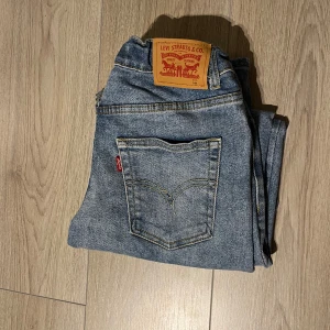 Blå jeans från Levi's - Snygga blå jeans från Levi's med klassisk femficksdesign och ikonisk läderpatch baktill. Perfekta för en avslappnad stil.