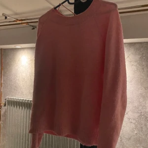 Rosa tröja från Vero Moda - Säljer en mysig rosa tröja från Vero Moda. Den har en enkel design med rund hals och långa ärmar, perfekt för kyligare dagar. Tröjan är tillverkad i ett mjukt material som ger en skön känsla.