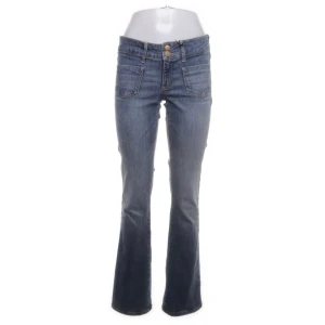 Blå bootcut jeans - Snygga blå bootcut jeans med låg midja. Jeansen har dubbla knappar och dragkedja framtill. 