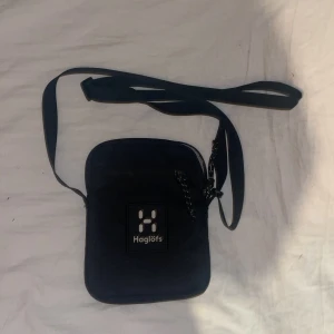 Svart axelväska från Haglöfs - Snygg svart axelväska från Haglöfs med justerbar rem och dragkedja. Knappt använd. 