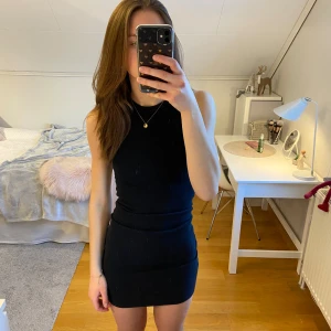 Svart ribbad klänning från Bik Bok - Snygg svart ribbad miniklänning från Bik Bok i storlek XS. Klänningen är ärmlös och har en tight passform som framhäver figuren. Perfekt för en stilren look.