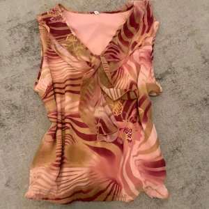 Mönstrad ärmlös blus med knyt vintage  - Jättesnygg nostalgisk topp, fick av min mamma men aldrig använt  I nyskick !!  Storlek 42 men passar som S, sitter lite flowigt på 
