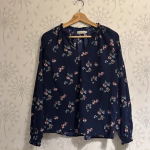 Blå blus blommig  - Säljer snygg blus med blommor storlek S oanvänd.