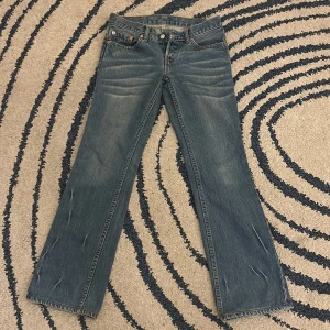 Low waist Levi's jeans i blå denim - Snygga Levi's jeans i klassisk blå denim med en straight passform. De har en knappgylf med två knappar och femficksdesign. Perfekta för vardagen. Säljer då dom är för små. Storlek w27 L32❤️