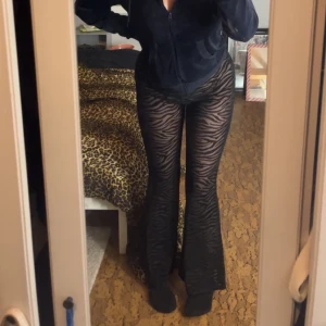 Svarta zebramönstrade byxor - Snygga svarta byxor med zebramönster. Byxorna har en tight passform upptill och blir vidare nedtill. Genomskinliga som ni märker.