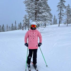 Rosa skidjacka från Dope - Säljer en snygg rosa skidjacka från Dope med svart tryck framtill. Den har en stor ficka på magen och justerbar huva med vita snören. Perfekt för kyliga dagar i backen eller till vardags.