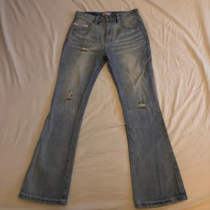 Blå flared jeans från bracca  - Snygga blå flared jeans från bracca med slitna detaljer. Klassisk femficksdesign och en bekväm passform. Perfekta för en avslappnad stil.