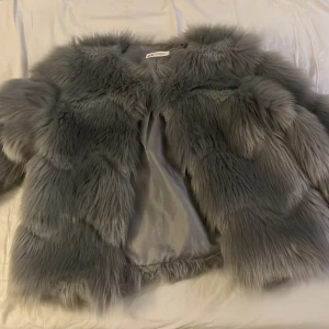 Grå pälsjacka från HM - Jättefin päls jacka från hm som knappt är använd därför bra kvalité på den. Det står på lappen att det är storlek 158 men skulle säga att den passar som xs. Använd 1-2 gånger. Billigt pris.