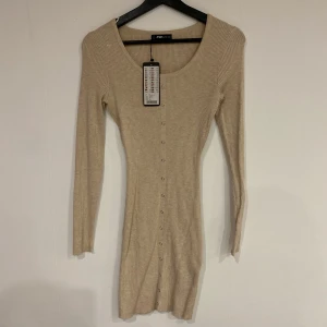 Beige stickad klänning från newyorker - Snygg beige ribbad klänning från newyorker som aldrig är använd. Klänningen har en tight passform och är ungefär lår-längd.