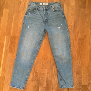 Mom Jeans  - Säljer ett par jeans i modellen Mom från Bherska. Dom är använda ett fåtal gånger (2-3) och är därav i mycket bra skick. Midjemått rakt över: 37 cm, Innerbenslängd: 64 cm och Ytterbenslängd: 100 cm. 