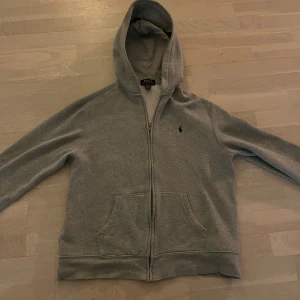  Polo Ralph Lauren zip up - Säljer en klassisk grå hoodie från Polo Ralph Lauren med dragkedja och huva. Tröjan har en broderad logotyp på bröstet och praktiska fickor framtill. Perfekt för en avslappnad stil. Nypris är runt 1000-1500kr, mitt pris 650kr 😁Hör av dig vid minsta lilla fundering 😊