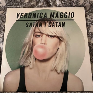 Satan i gatan - Vinylskiva av Veronica Maggio med titeln 'Satan i gatan'. Omslaget visar en bild av veronica som blåser en rosa tuggummibubbla. Skivan är inprincip oanvänd, endast tagit ut skivan ett par gånger.