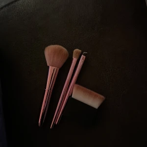 Set med sminkborstar i roséguld - Snyggt set med tre sminkborstar i roséguld. Innehåller en stor borste för puder eller bronzer, en mindre borste för ögonskugga och en vinklad borste för detaljerad applicering. Perfekt för att skapa en komplett look.