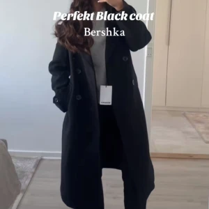 Svart kappa från Bershka - Köptes för 2 v sedan för 859kr! Den är lite oversized. Vill sälja på grund av att jag ångra mig angående storleken och vill därmed byta storlek. Snygg varm svart kappa från Bershka med knappar och bälte i midjan 💕sista pris 500kr