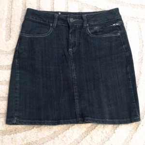 Y2K mini denim skirt! - Snygg mörkblå jeanskjol från Capri Collection med klassisk femficksdesign och knappdetaljer. Perfekt för en avslappnad stil. Kjolen har en bekväm passform och är lätt att matcha med olika toppar.