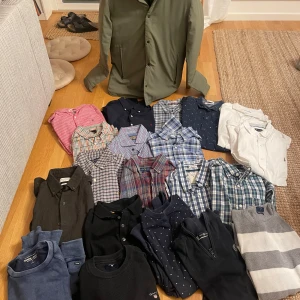 Samling av skjortor i olika färger och mönster - En samling av skjortor och tröjor  i olika färger och mönster, inklusive randiga och rutiga. Märken Ralph Lauren  och Peak mm. Skickar även med en oanvänd jacka. Allt i storlek medium 