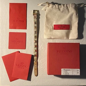 Nitarmban från Valentino - Snygg och trendigt silver armband med guldnitar från Valentino, passar perfekt för alla tillfällen. Sliten färg på nederdelen dock inget som syns när du bär det. 