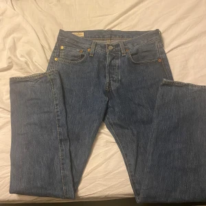 Levis 501 jeans - Klassiska Levis 501 jeans i blå denim. De har en rak passform med knappgylf och fem fickor. Perfekta för en avslappnad stil.Skick:9/10 använda Max 2 gånger 