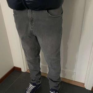 Grå jeansbyxor - Snygga grå jeansbyxor med en straight passform. Byxorna har en klassisk femficksdesign och är perfekta för en avslappnad stil. De är tillverkade i ett slitstarkt material som ger en bekväm känsla hela dagen. Personen på bilden är 175.