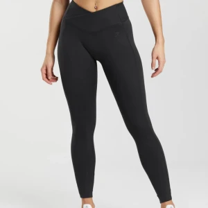 Svarta Crossover Leggings Gymshark NY - Snygga och bekväma svarta crossover leggings med hög midja. Perfekta för träning. Helt nya nypris 449