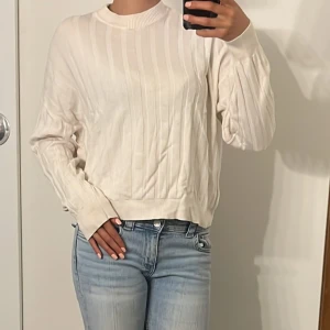Vit/ beige stickad tröja från Pernilla Wahlgren - Säljer en stilren vit /beige stickad tröja från Pernilla Wahlgren. Tröjan har ett diskret ribbat mönster och långa ärmar (noppror finns på tröjan)💕