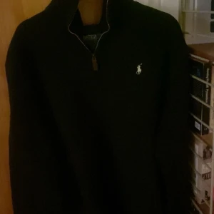 Ralph lauren halfzip svart  - Säljer denna feta Ralph lauren half zipen då den tyvärr är för stor för mig. Tröjan är i mycket bra sick förutom en liten defekt på sidan som syns på sista bilden.  Hör av er om ni har några frågor👍