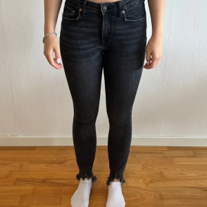 Svarta skinny jeans från Zara - Säljer ett par svarta skinny jeans från Zara i storlek 36. De är högmidjade och har en snygg fransdetalj vid bensluten. Perfekta för både vardag och fest!