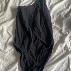 Svart baddräkt från Topshop - Säljer en svart enarmad body från Topshop i storlek 36. 