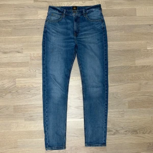 Lee Jeans ”Austin” - Ett par sköna och elastiska jeans från Lee i nyskick. ”Austin” modellen är regular fit, så de sitter lite lösare vid vaderna än slimfit. Vid eventuella funderingar så är det bara att höra av sig!