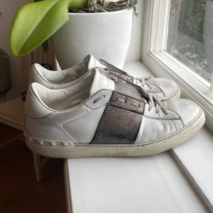 Valentino skor - Säljer ett par vita valentinos med brons band. De är lite slitna, men fortfarande i bra skick för vardagsbruk. Köpte dem på vestaire med Authentication men de har ingen box.