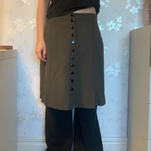 grön kjol - cool mörkgrön kjol i skönt material. kan ha high-, mid- eller low waist. snygg att ha över brallor. inga defekter. skriv gärna om mer info, mått eller pris.