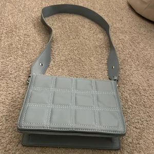 En blå väska  - Ett jätte fin blå väska från något ställe i polen. Den har lite märken på baksidan man inte kommer se när man har på dig den.