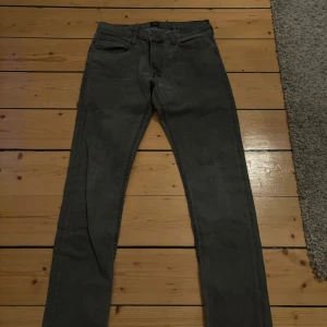 Grå jeans från Lee - Snygga grå jeans från Lee i modellen Luke. De har en klassisk femficksdesign och är tillverkade i ett slitstarkt denimtyg. Perfekta för en stilren look.
