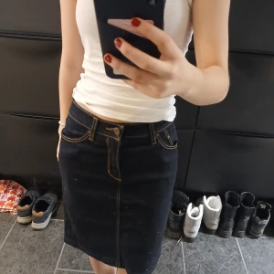 Mörkblå jeanskjol från Dobber - Snygg mörkblå jeanskjol från Dobber i storlek XS. Kjolen har en klassisk design med knappar och dragkedja framtill samt kontrastsömmar.